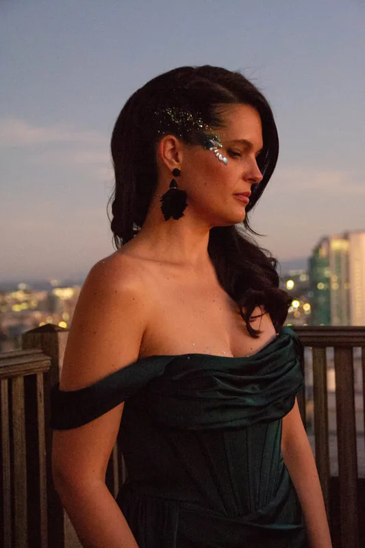 A woman on a balcony in San Francisco wearing a hand made jewel cluster from the Bling Bar