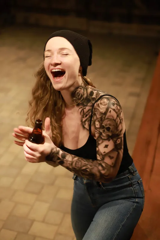 a laughing young white woman with blonde hair modeling two full sleeves of waterproof airbrush tattoo's in Sausalito, California