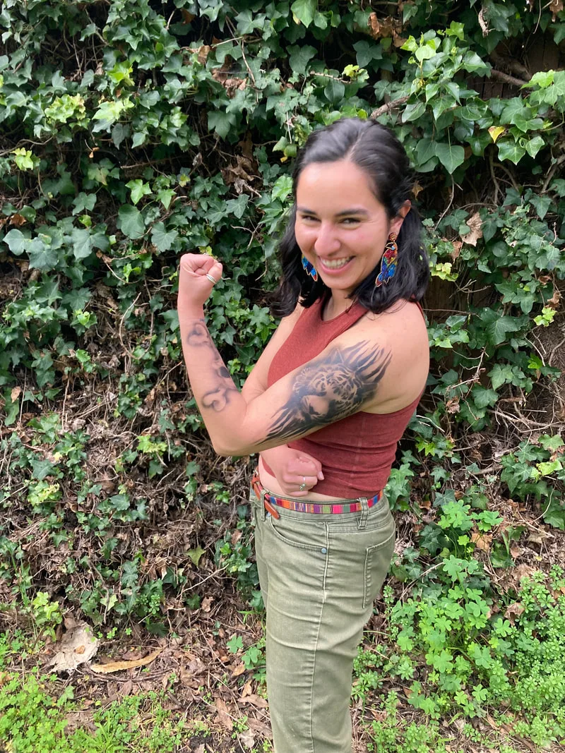 A young woman in the San Francisco Bay Area flex's her arm to show her tiger airbrush tattoo