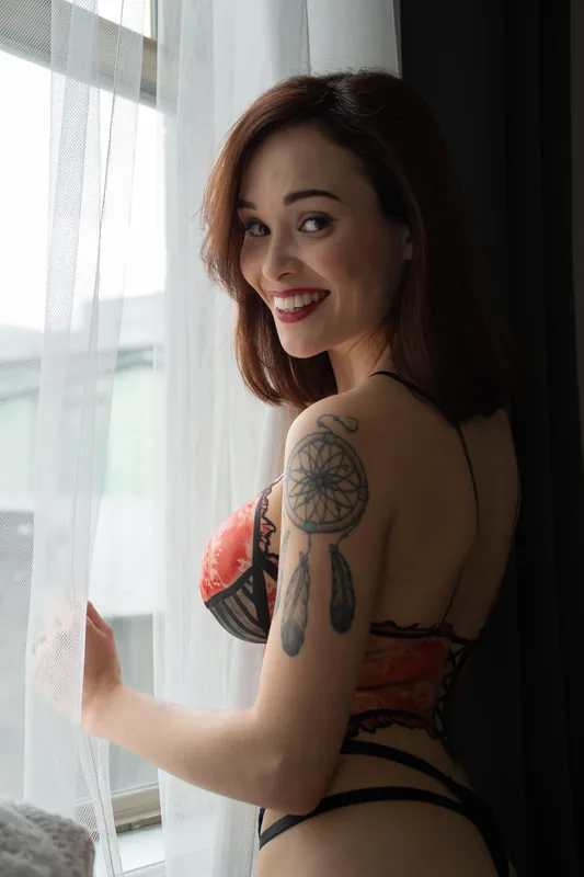 A woman in a boudoir photoshoot wearing body paint that looks like red and black lingerie in Berkeley, California.
