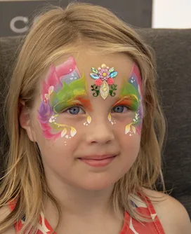 Bay Area child with rainbow fairy butterfly face paint and elaborate hand made jewel piece